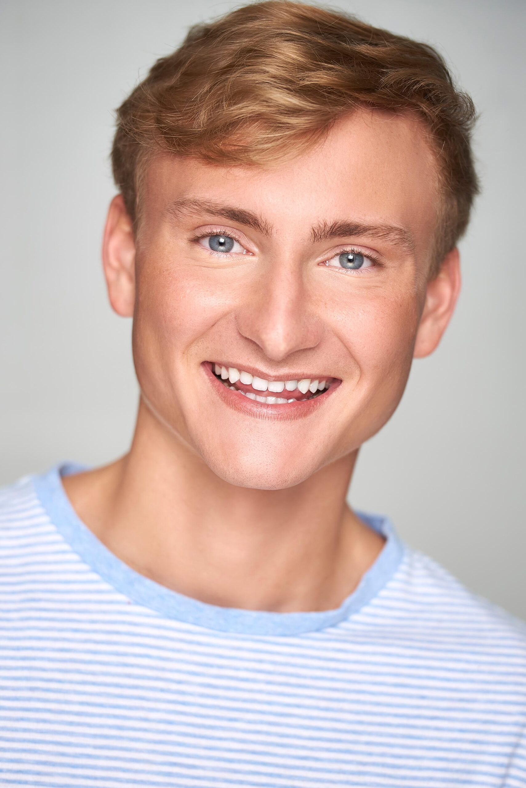 Actor posing for commercial headshots showing versatile expressions, Bright and engaging commercial headshots for aspiring actors, Professional commercial headshots capturing a performer's charisma, Close-up of an actor in a commercial headshots session, Commercial headshots showcasing an actor's friendly demeanor, Actor’s headshot with a natural, approachable look for commercial casting, Vibrant commercial headshots reflecting an actor's on-screen potential, Expressive commercial headshots for a television series audition, Headshot of an actor with a dynamic commercial look, Actor in a studio for commercial headshots highlighting their unique style