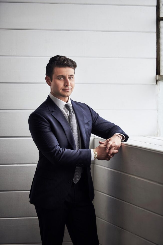 Sharp dating profile photo for men in San Francisco, Professional lifestyle portrait of a man in a navy suit near a window, Confident dating app photo for Hinge Bumble and Tinder, Online dating photographer San Francisco image with polished wardrobe and natural light.