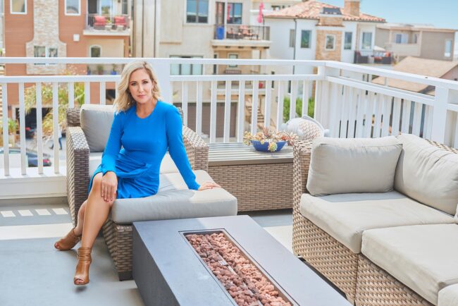 Realtor lifestyle photo in Los Angeles, professional woman seated on a residential balcony with neighborhood views, polished image for realtor website, Zillow profile, social media, marketing, and personal branding