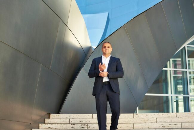 Urban realtor branding photo in Los Angeles, professional man in suit photographed against a modern architectural exterior, polished image for realtor website, Zillow profile, social media, marketing, and personal branding