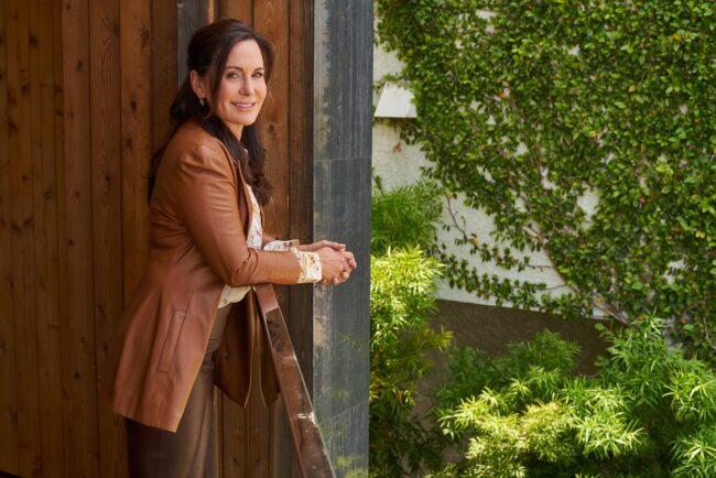 Realtor lifestyle photo in Los Angeles, professional woman photographed on a home balcony with greenery, polished image for realtor website, Zillow profile, social media, marketing, and personal branding