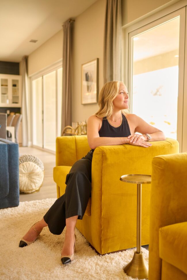 Realtor lifestyle photo in Los Angeles, professional woman seated in a modern living room with large windows, polished image for realtor website, social media, marketing, and personal branding