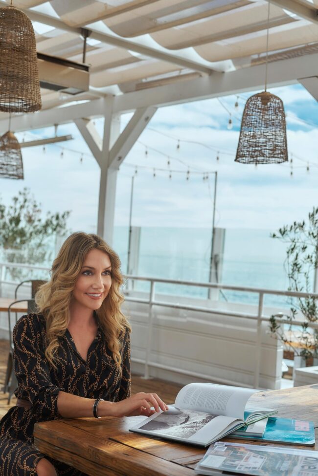 Realtor lifestyle photo in Los Angeles, professional woman seated in a coastal home setting, polished image for realtor website, social media, marketing, and personal branding