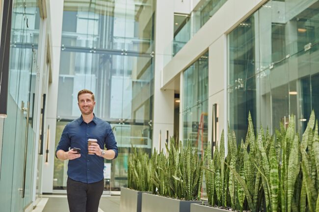 Environmental professional headshot in Los Angeles, man photographed in a modern office setting with a coffee and phone, useful for website bio, LinkedIn profile, company profile, professional profile, and online presence