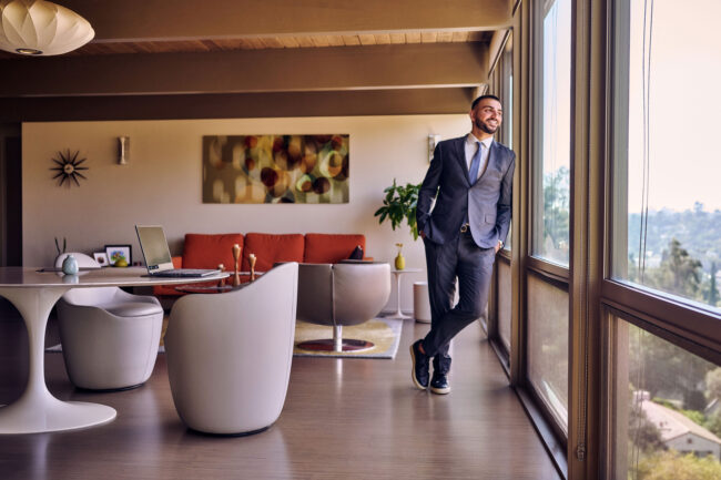 Realtor lifestyle photo in Los Angeles, professional man in suit photographed inside a modern home interior near large windows, polished image for realtor website, Zillow profile, social media, and marketing