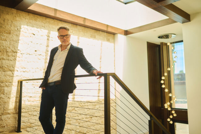 Realtor lifestyle photo in Los Angeles, professional man photographed inside a modern home interior with architectural details, polished image for realtor website, Zillow profile, social media, and marketing