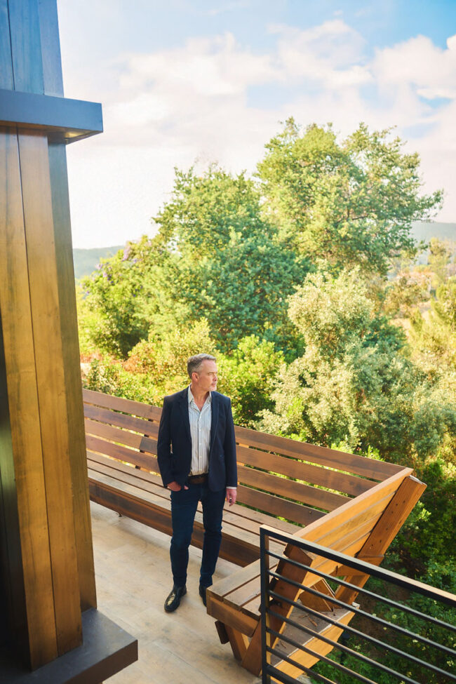 Outdoor realtor lifestyle photo in Los Angeles, professional man photographed on a modern home deck with greenery, polished image for realtor website, social media, marketing, and personal branding