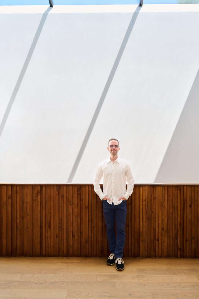 Realtor lifestyle photo in Los Angeles, professional man photographed in a modern home interior with wood paneling and natural light, polished image for realtor website, Zillow profile, social media, marketing, and personal branding