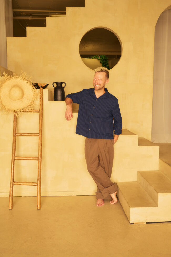 Realtor lifestyle photo in Los Angeles, professional man photographed in a warm home interior with architectural stairs, polished image for realtor website, Zillow profile, social media, marketing, and personal branding
