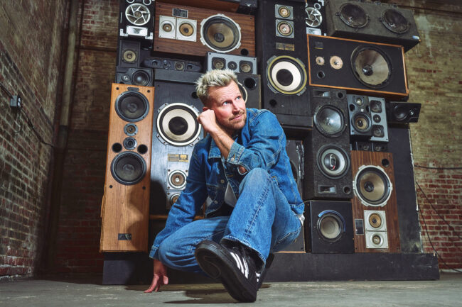 Realtor personal branding photo in Los Angeles, professional man photographed in a music studio with vintage speakers, personality-driven image for realtor website, social media, marketing, and personal branding