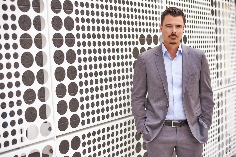 Modern corporate business portrait in Los Angeles, professional man in gray suit against an architectural wall, LinkedIn, company website, and executive bio image