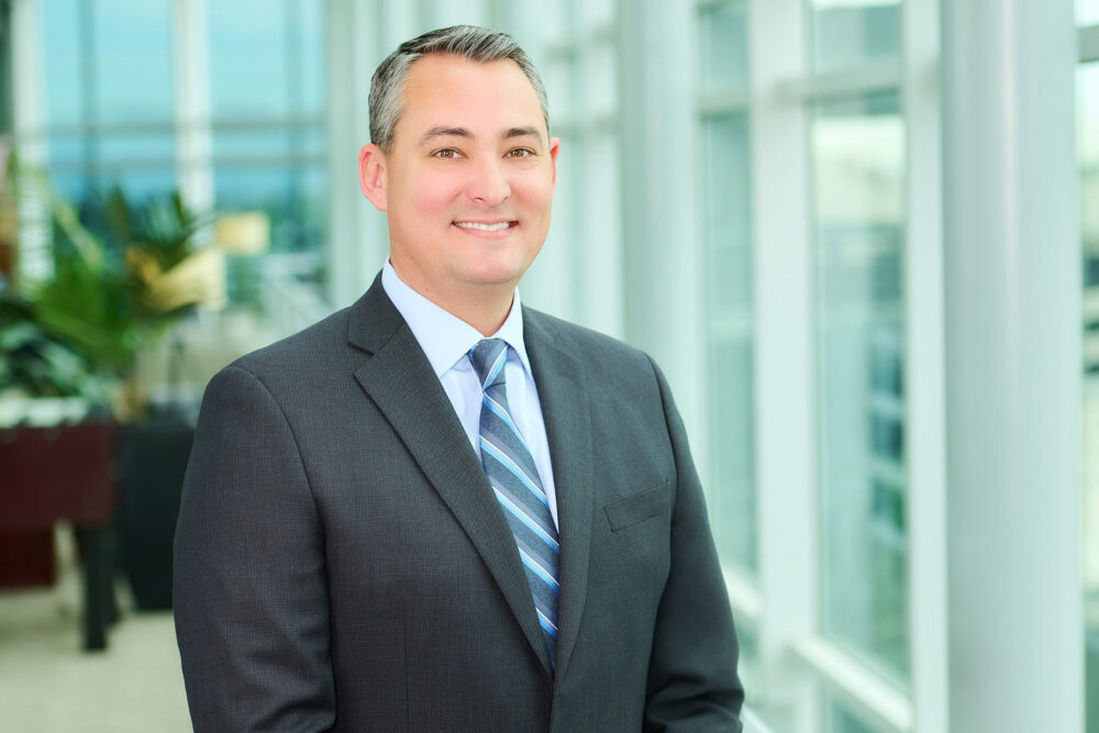 Office executive headshot in Los Angeles, professional business portrait with gray suit in a modern office setting, LinkedIn and company website profile image
