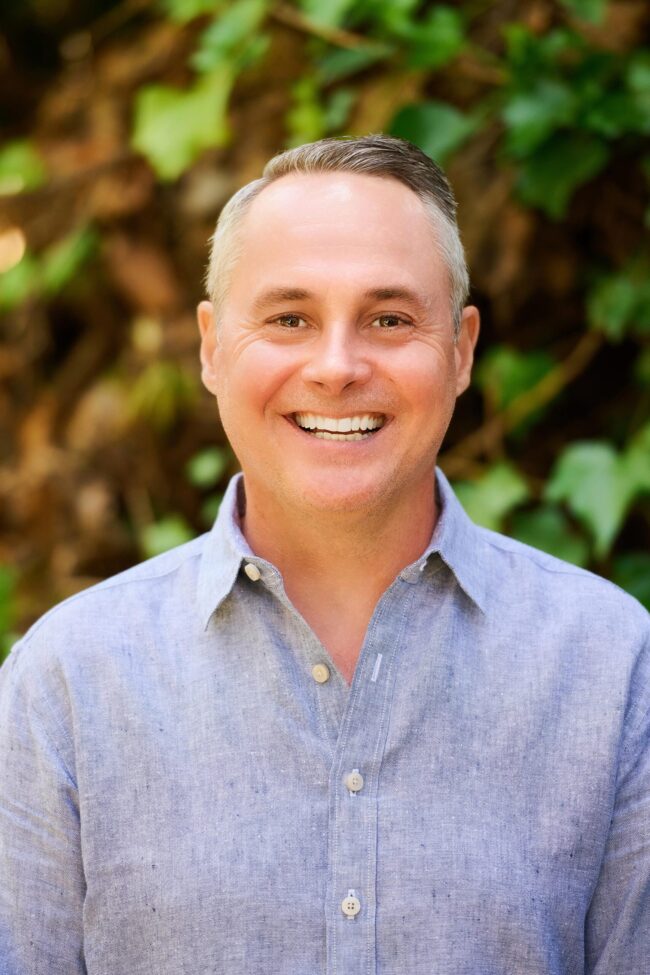 Outdoor business headshot in Los Angeles, approachable professional portrait with natural greenery background, LinkedIn and company website profile image