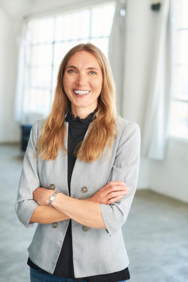 Professional business headshot in Los Angeles, woman in gray blazer photographed in a bright studio setting, LinkedIn and company website profile image
