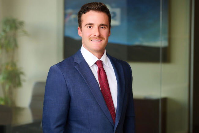 Professional headshot in Los Angeles, man in a blue suit and red tie photographed in a modern office setting, useful for website bio, LinkedIn profile, resume, company profile, and professional use