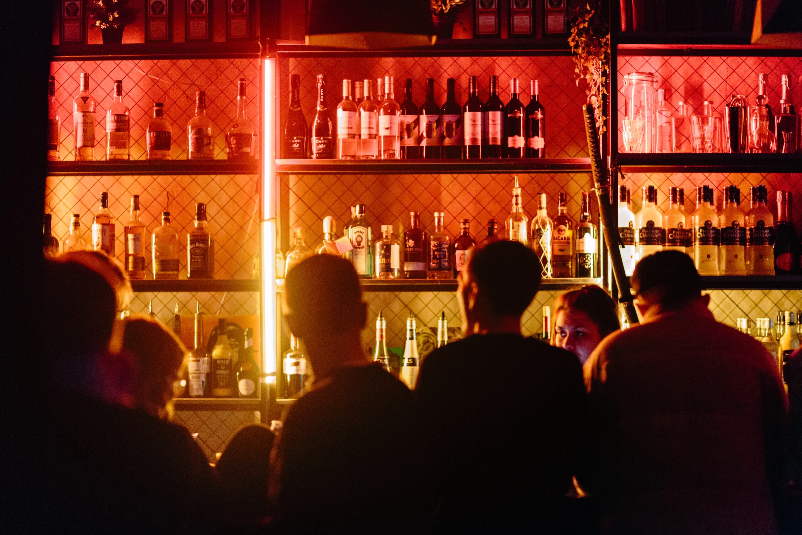 Bar Scene for Single Men in Los Angeles People gathered at a warmly lit bar with bottles on shelves and a busy evening atmosphere.